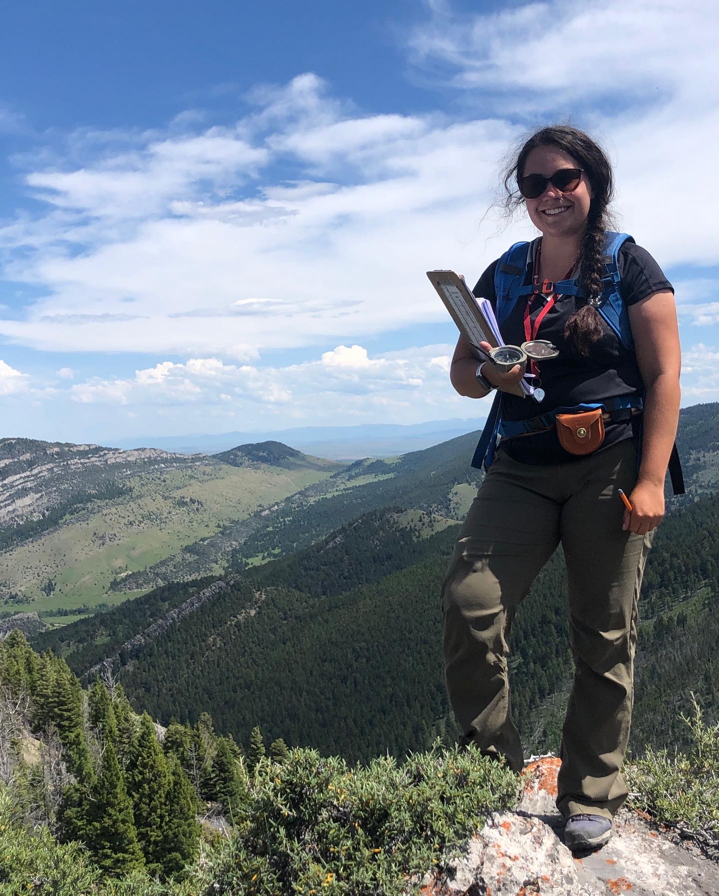 woman with dark hair posing outdoors wearing hiking clothes