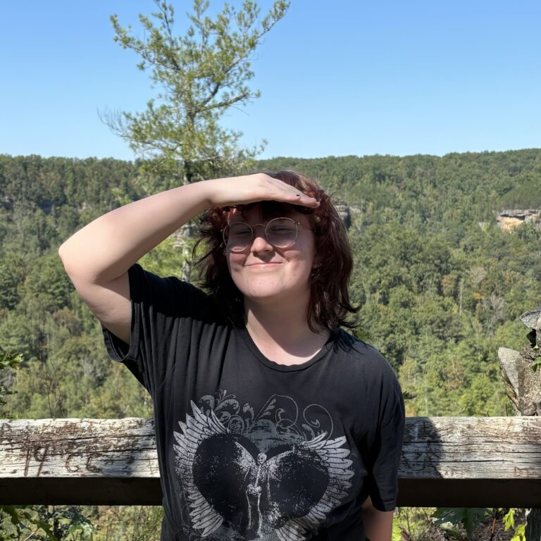 woman with red hair smiling with sun on her face